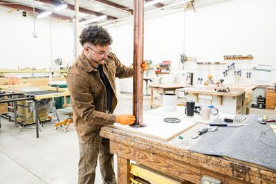 man staining wood in the workshop