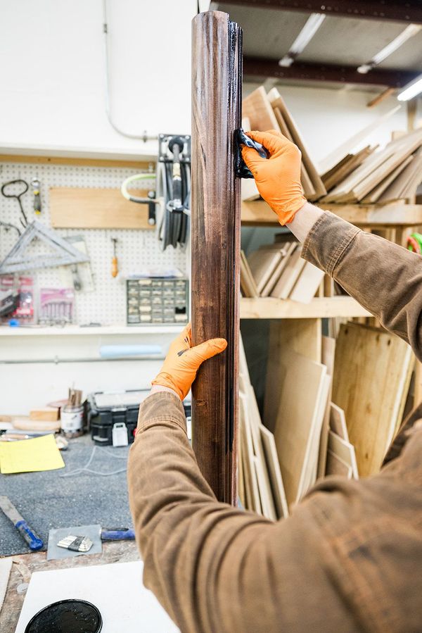 man staining wood in a workshop