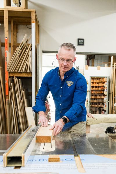 man cutting wood in the workshop