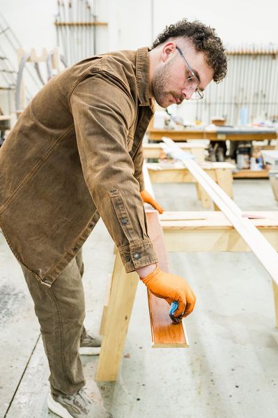 man staining wood in the workshop