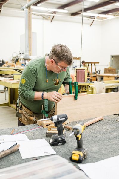 man building something out of wood in the workshop