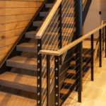 A staircase with metal and wood railing.